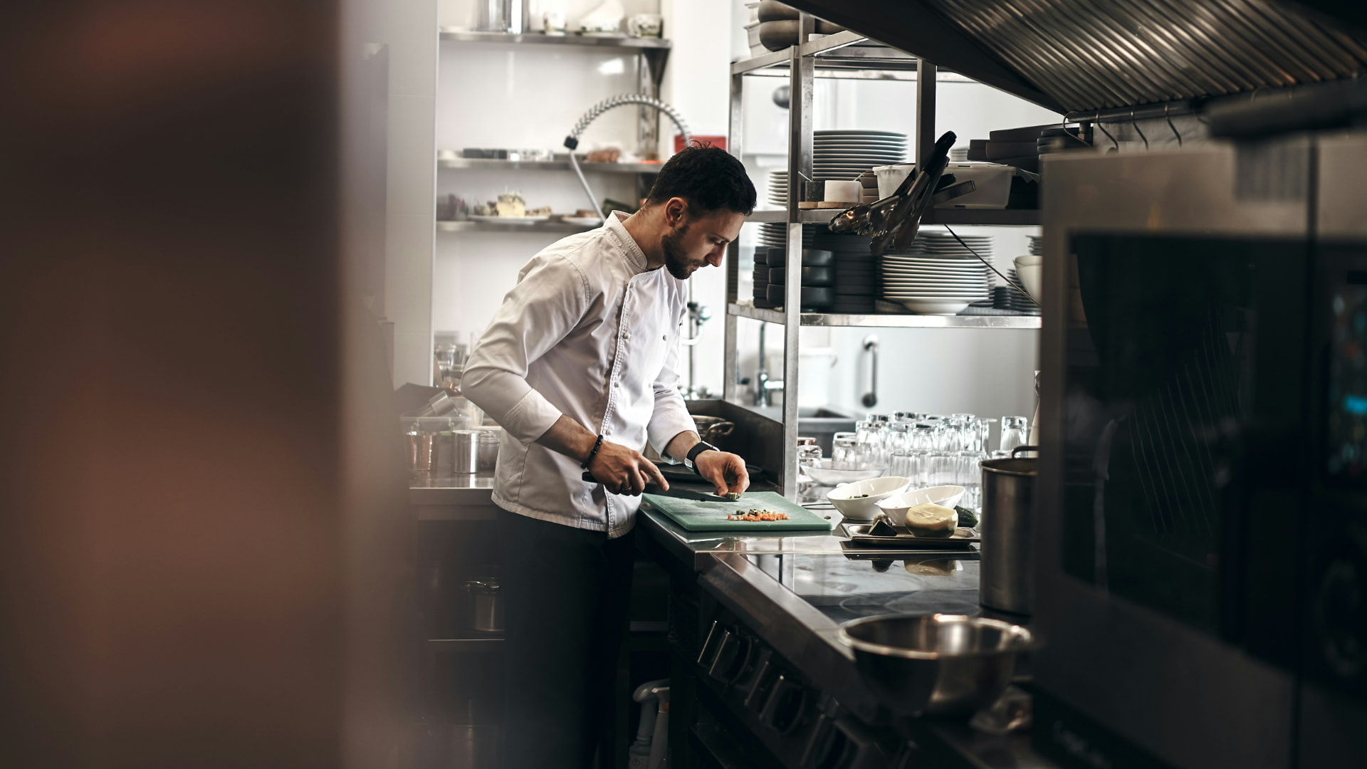 A chef dicing vegetables at a quiet prep station