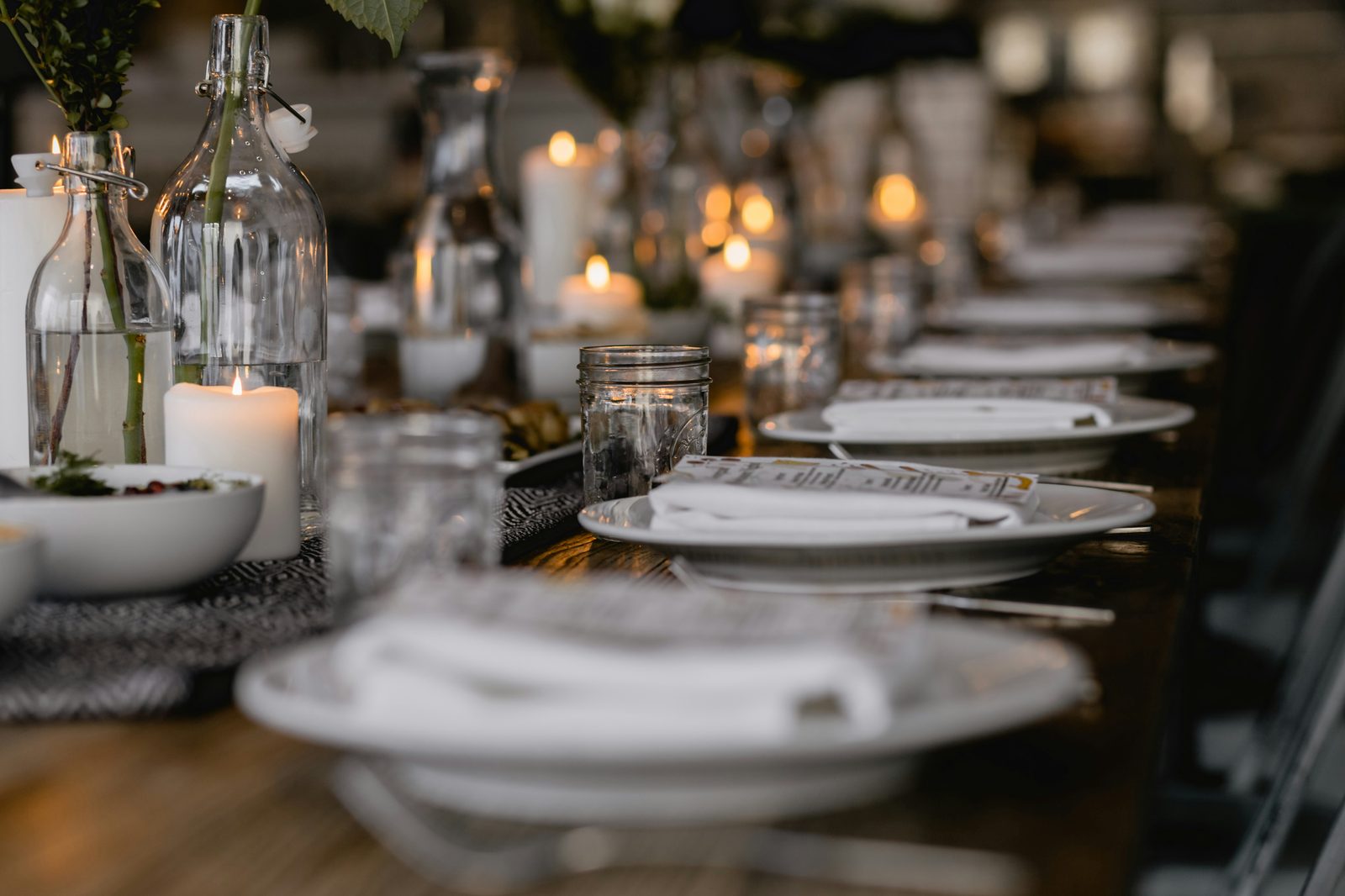 A long candlelit table set for a private dinner