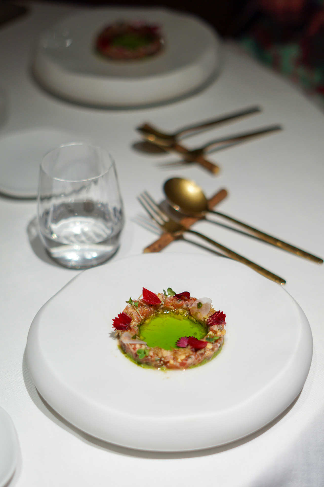 A delicate tartare with herb oil and edible flowers