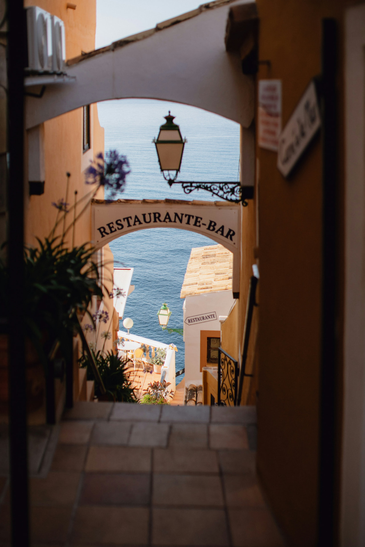A Restaurante-Bar sign framing a view of the Mediterranean