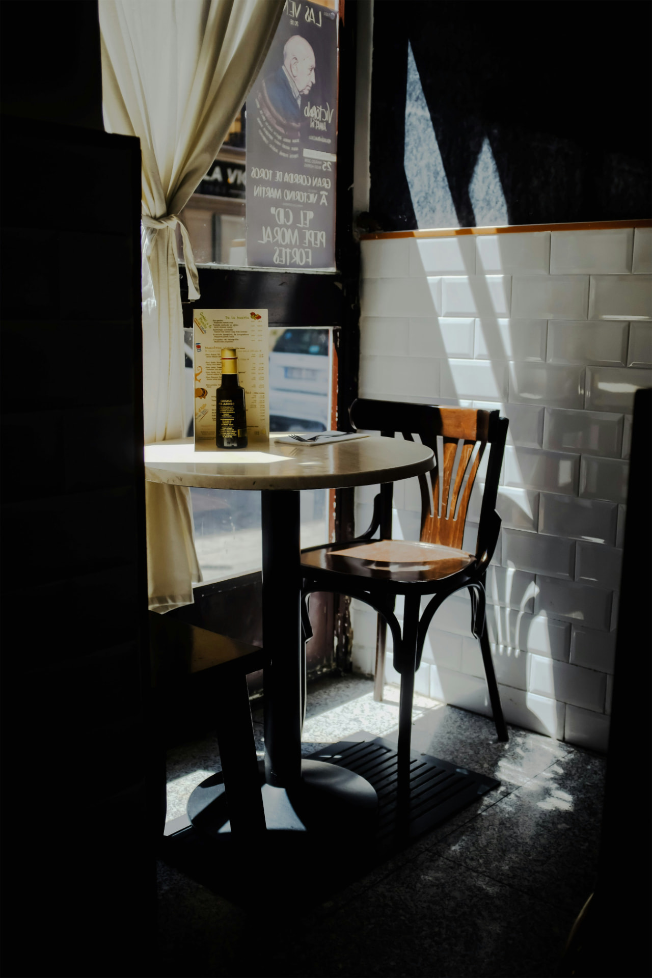 A marble café table and bentwood chair in afternoon light