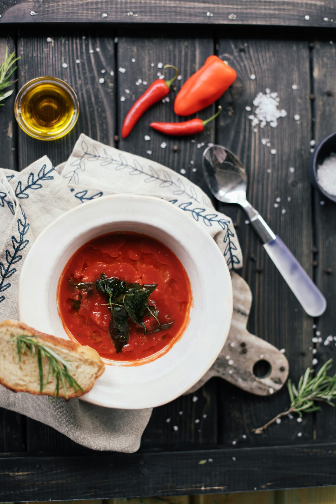 A bowl of tomato soup with fried herbs and toasted bread